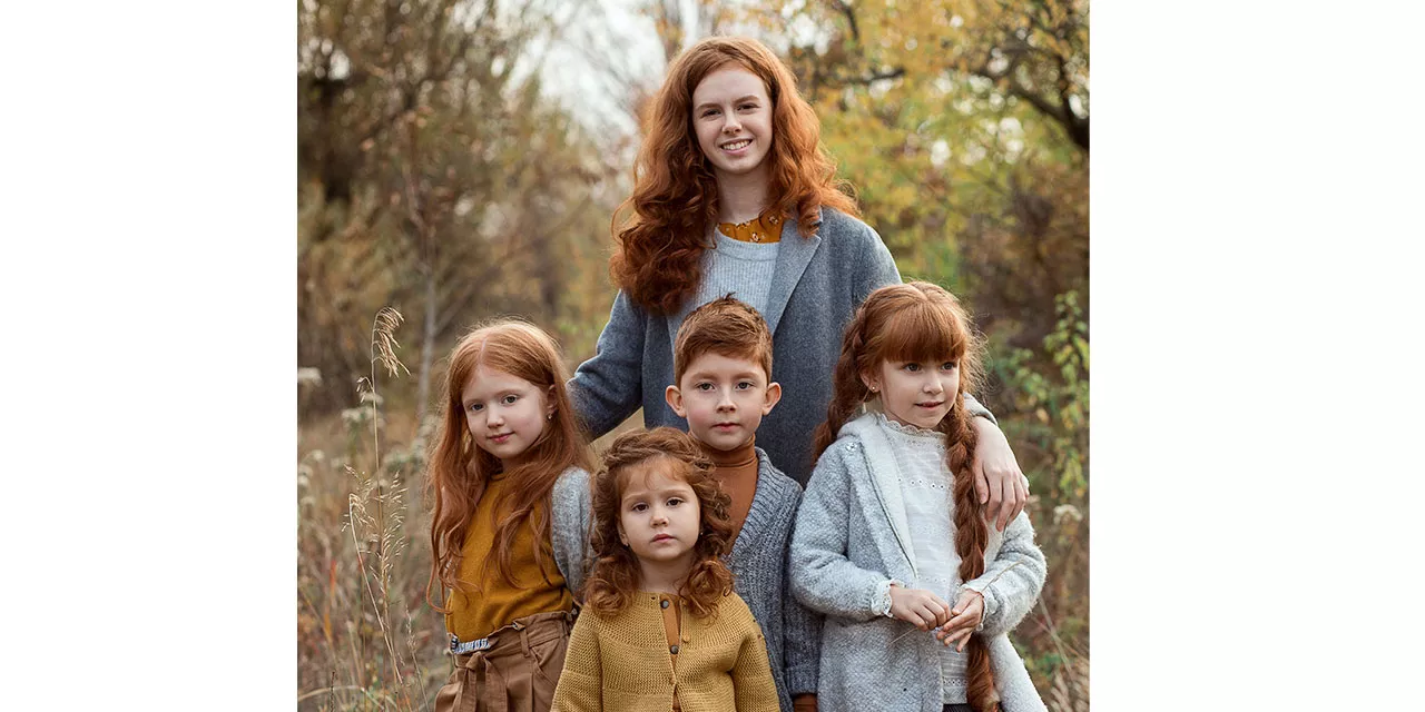 Familienfoto einer Mutter mit ihren vier jungen Kindern. Die Familie teilt eine gemeinsame rote Haarfarbe.