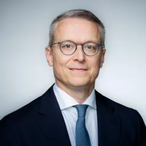 Portraitfoto von Karsten Wildberger im schwarzen Anzug.